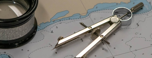 A group of people looking at a nautical chart on a light table